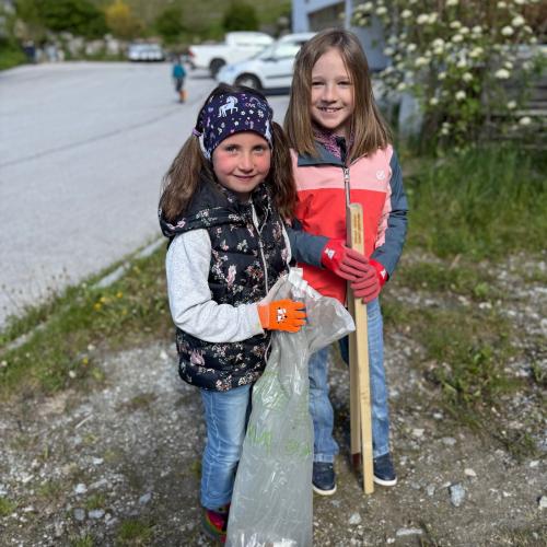 Kinder mit Müllzangen und Müllsäcken