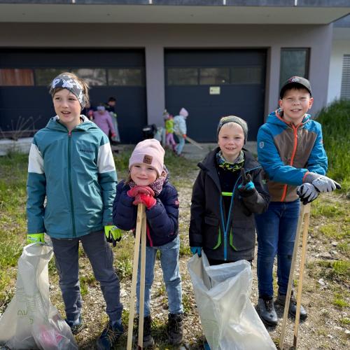 Kinder mit Müllzangen und Müllsäcken