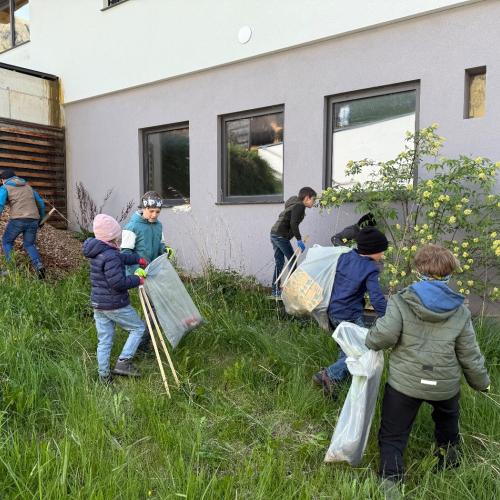 Kinder mit Müllzangen und Müllsäcken